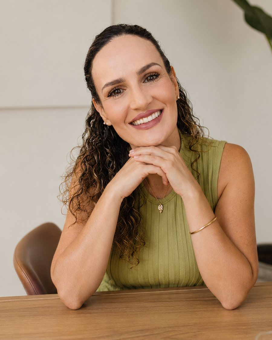 Fabíola Maldonado apoiada na mesa, no ambiente onde atende